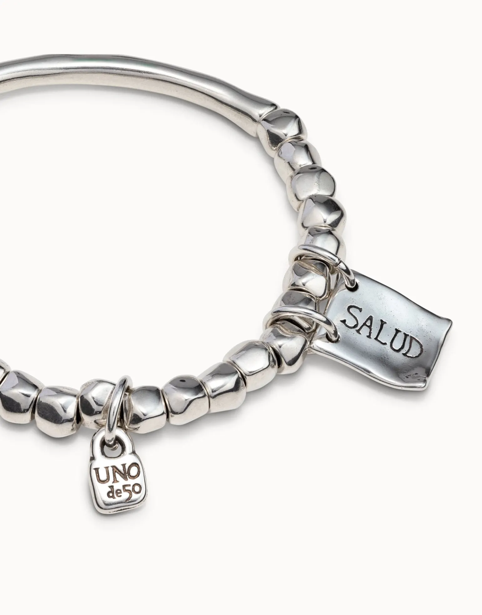 Beaded stretch bracelet with tubular piece and charms